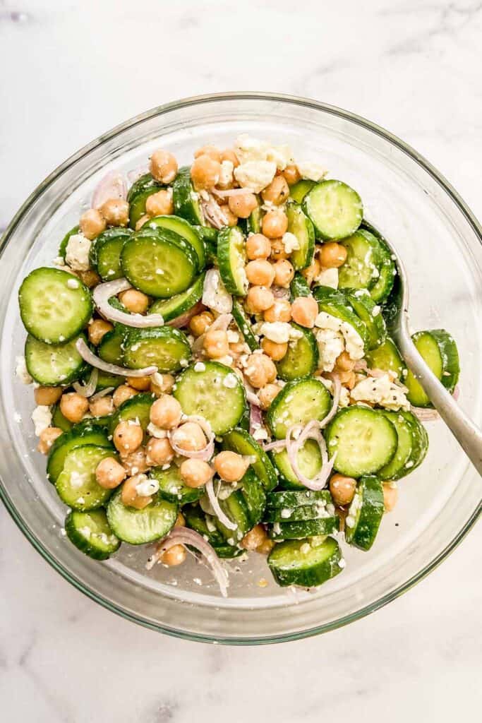 Chickpea cucumber salad with feta and shallots in a large glass bowl.