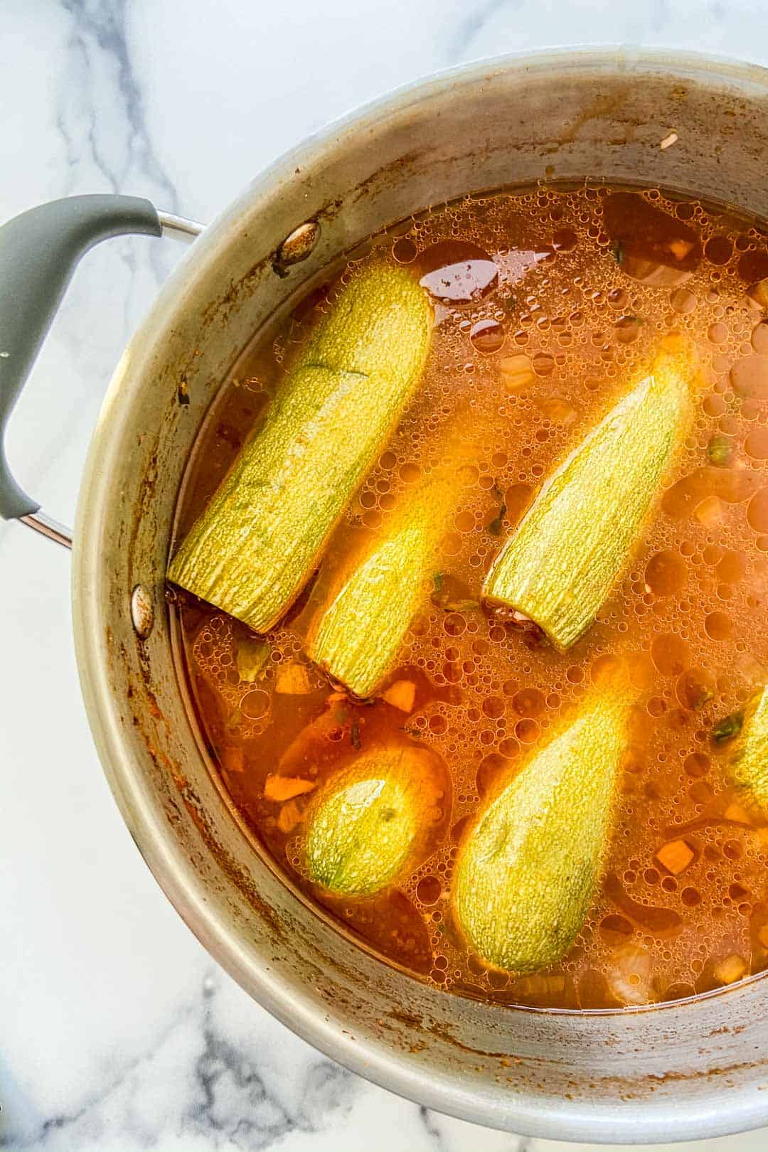 Kousa mahshi in a large pot with tomato.