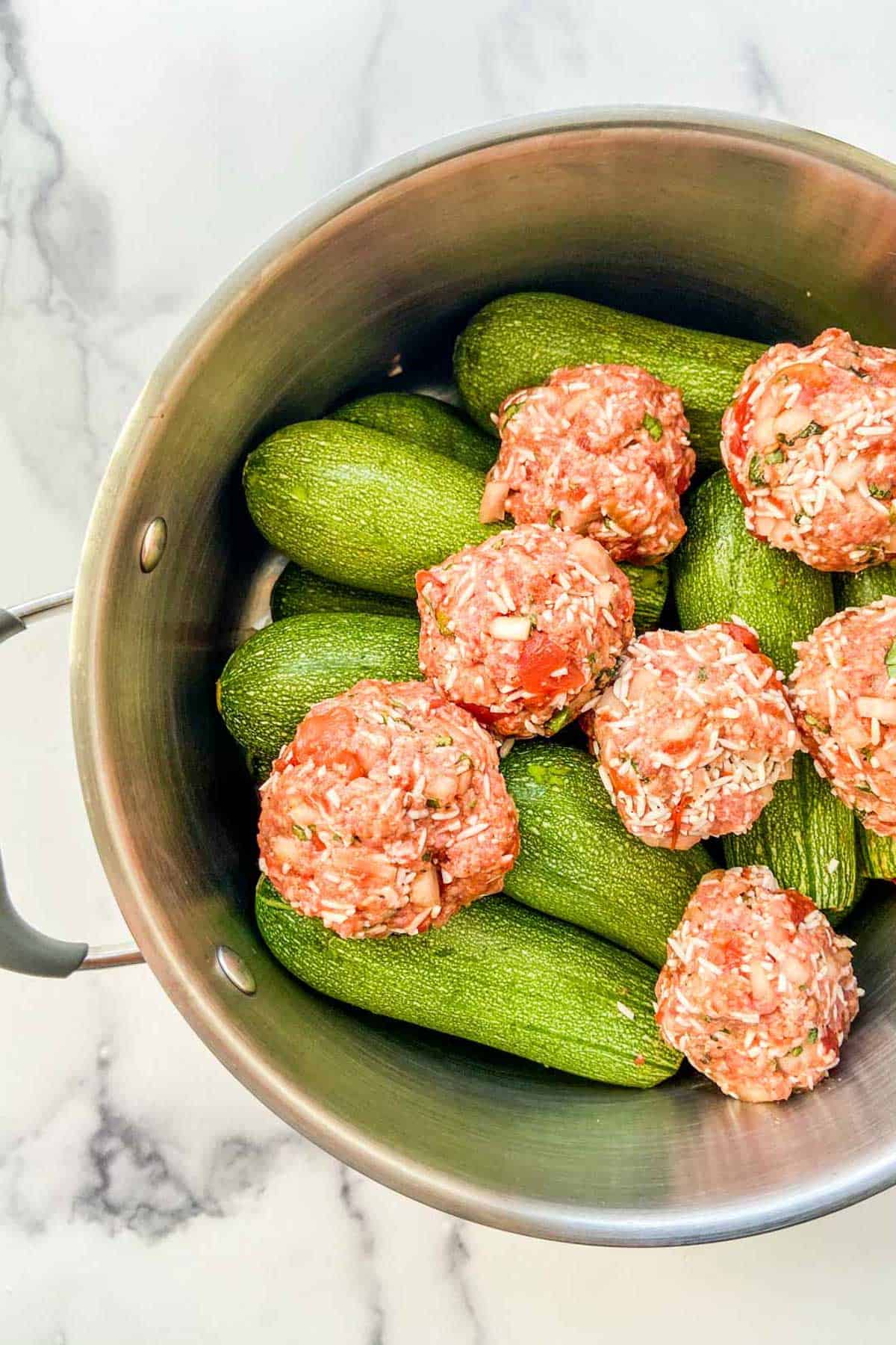 Meatballs and stuffed zucchini in a large pot.