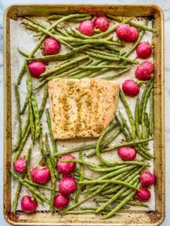 Salmon, green beans, and radishes on a sheet pan.