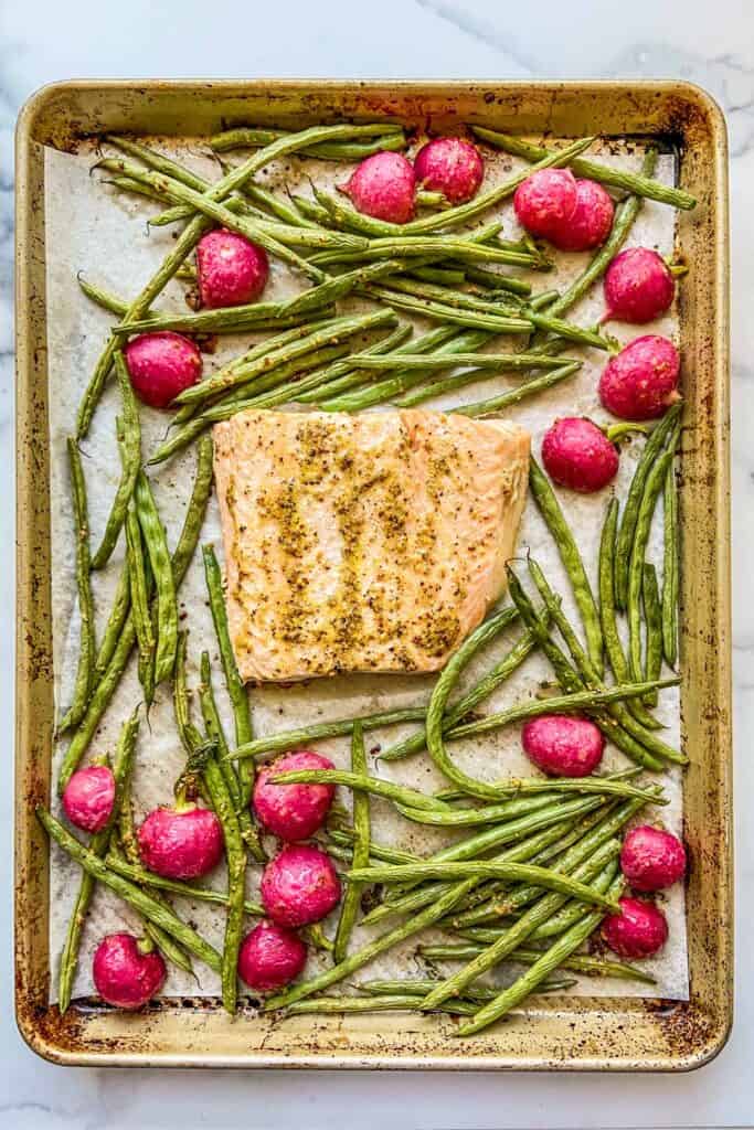 Salmon, green beans, and radishes on a sheet pan.