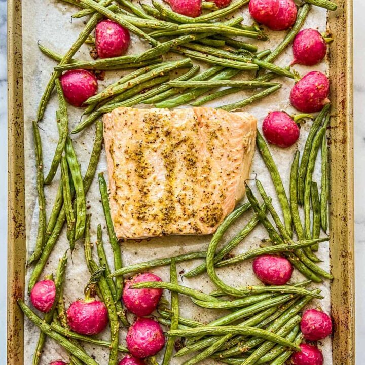 Salmon, green beans, and radishes on a sheet pan.