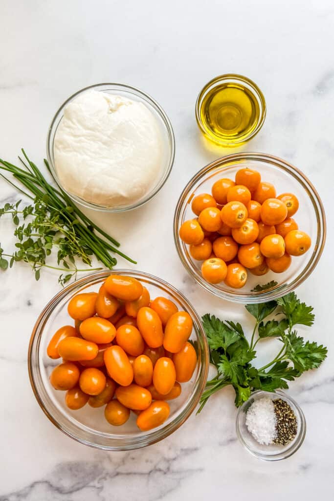 Bowls of ingredients for goldenberry tomato salad with buratta. 