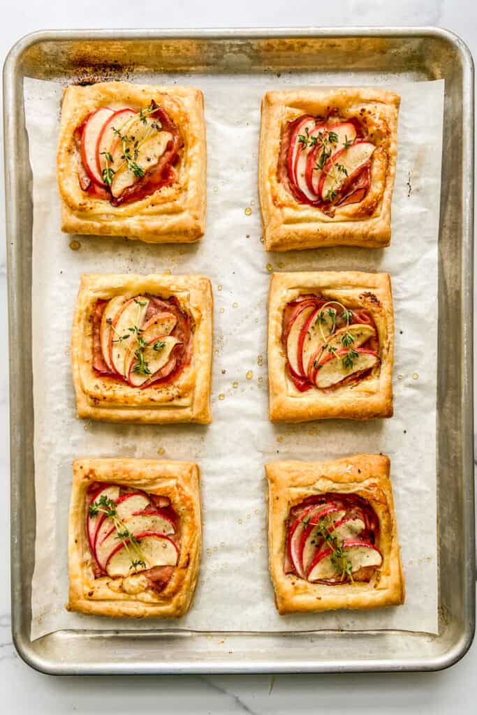 Ham and cheese tarts on a baking sheet.