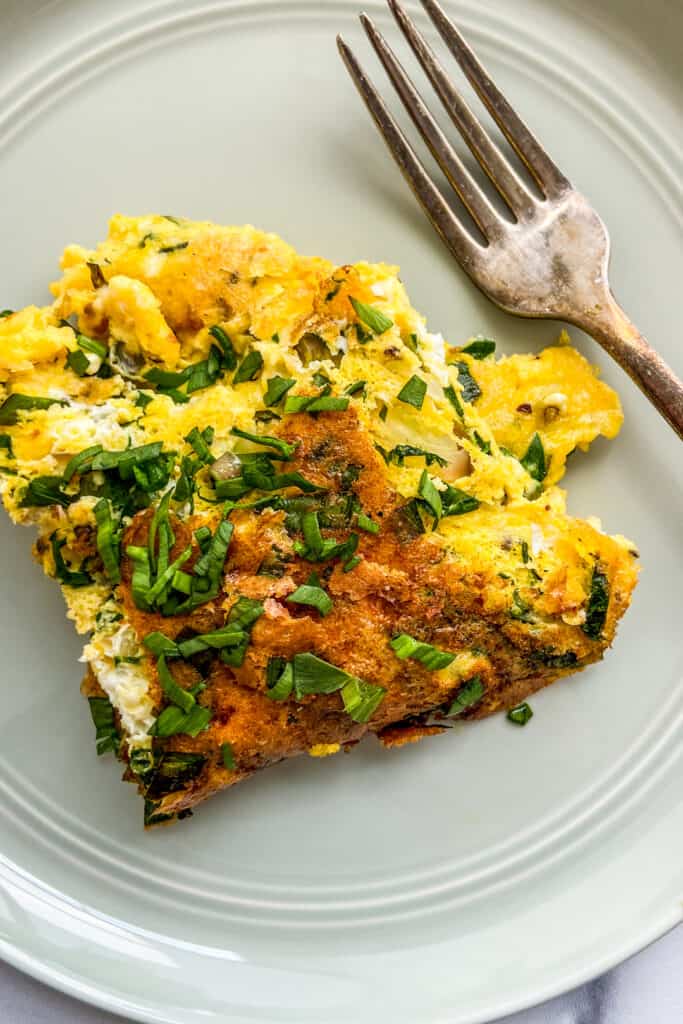 A closeup shot of a ramp omelet on a green plate.