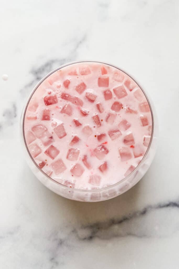 An overhead shot of a glass of strawberry milk.