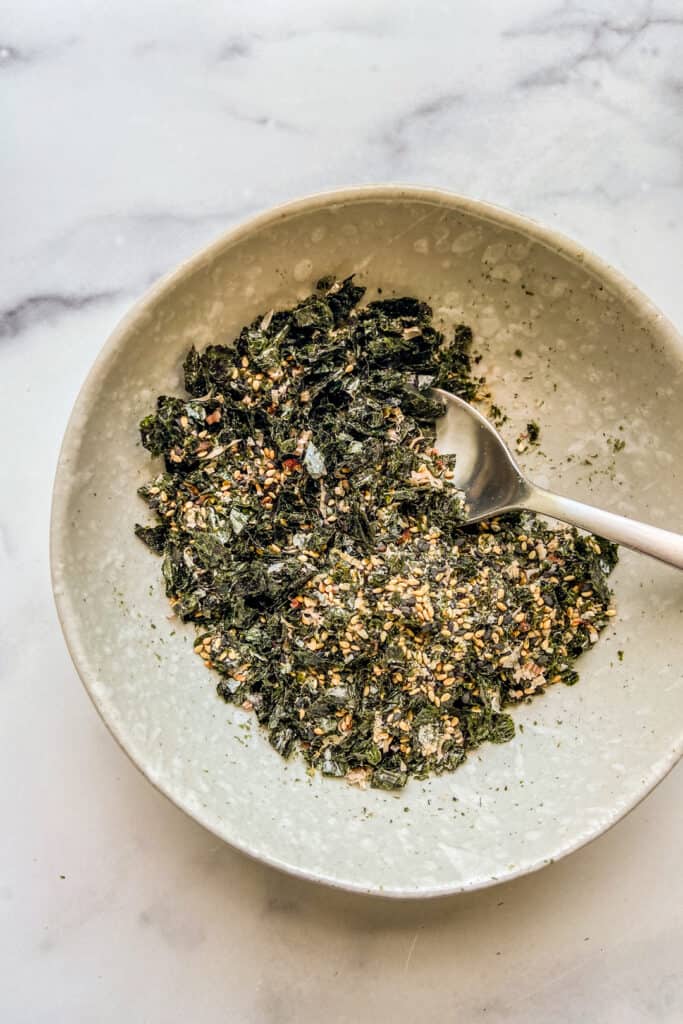 An overhead shot of a bowl of furikake seasoning with a spoon.