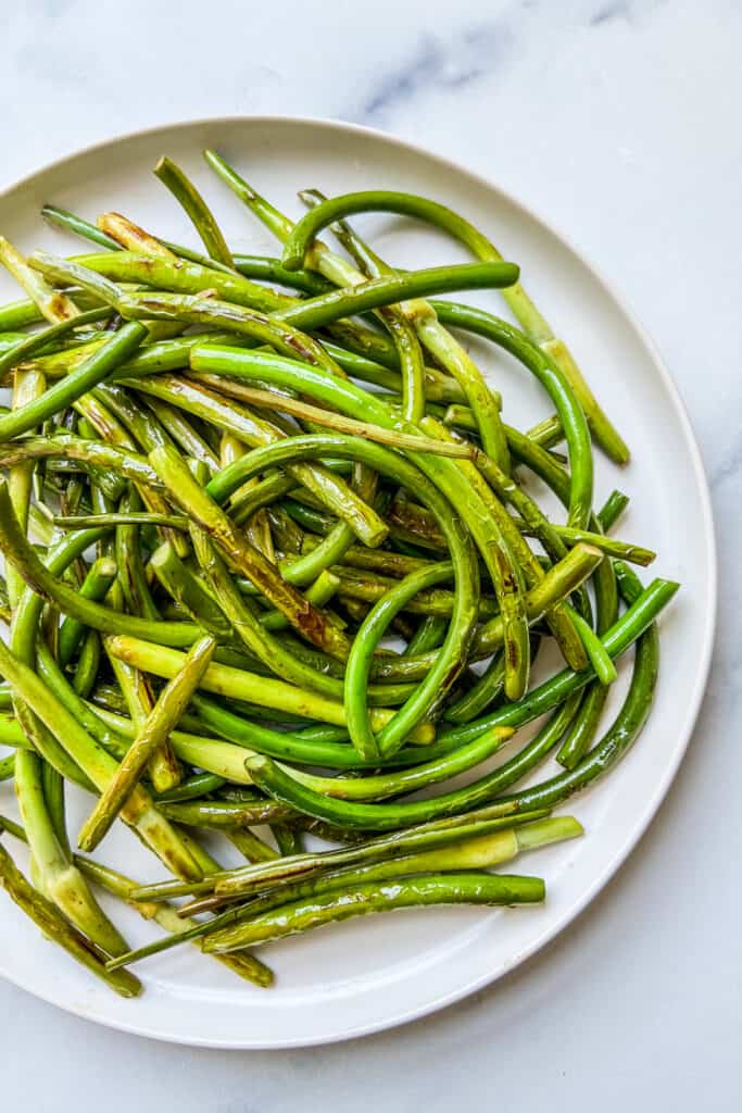 An overhead shot of a plate of cooked scapes.