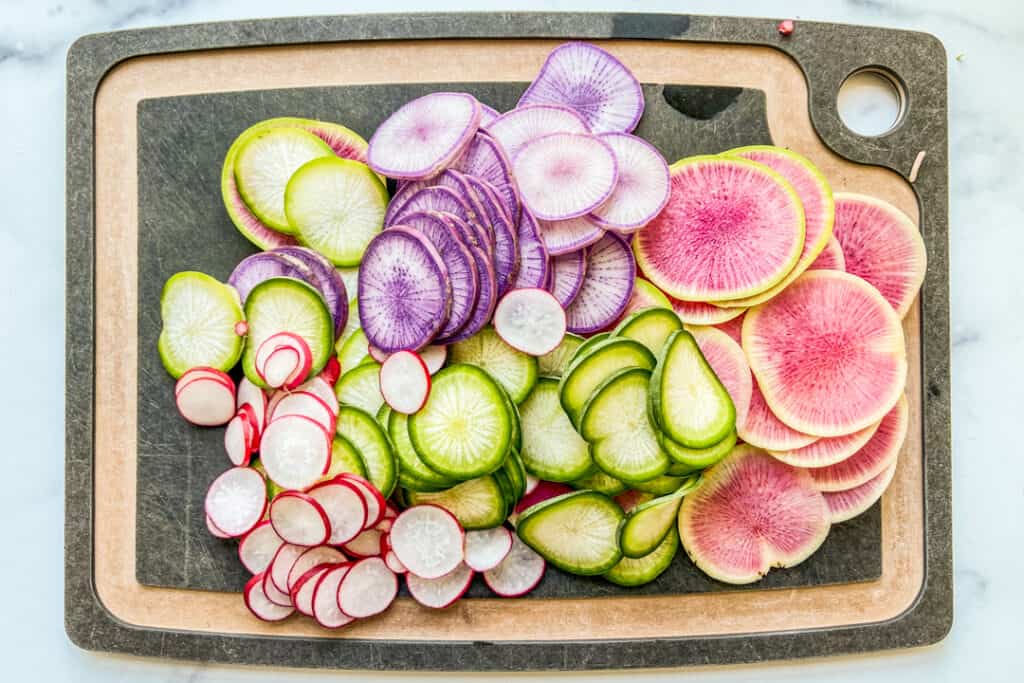 Sliced radishes on a cutting board.