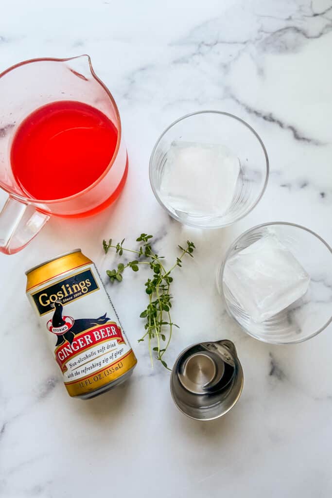 Ingredients for a rhubarb shrub on a marble backdrop.