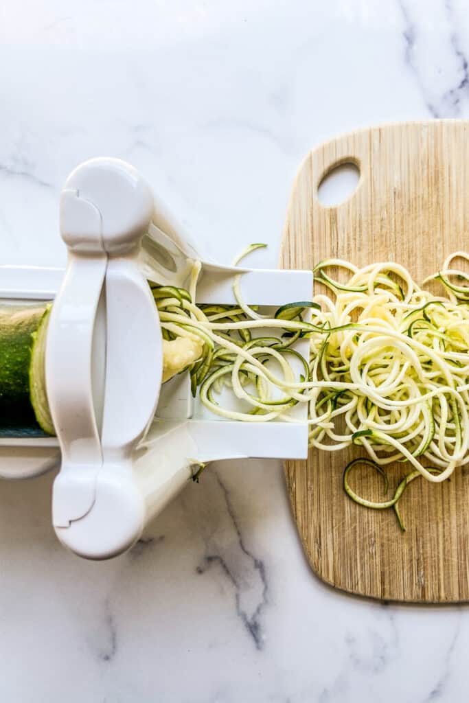 A zoodle maker and zucchini noodles.