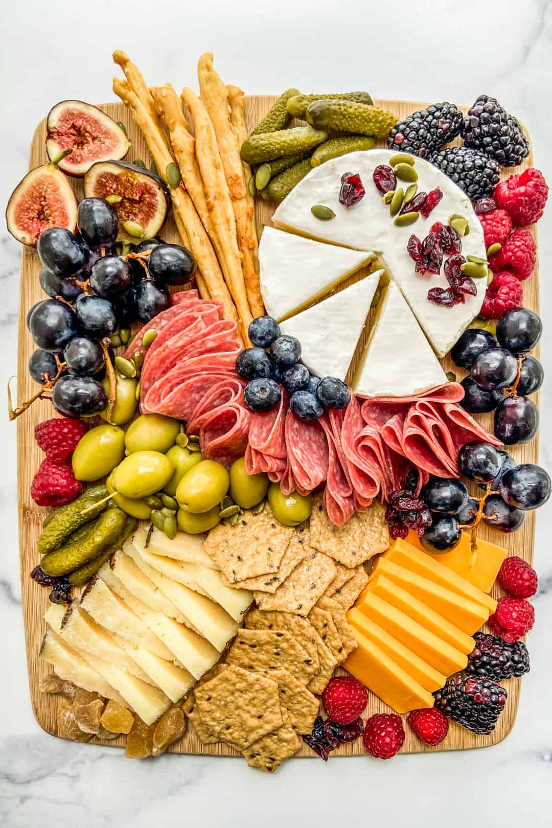 An overhead shot of a fall charcuterie board on a wooden board.