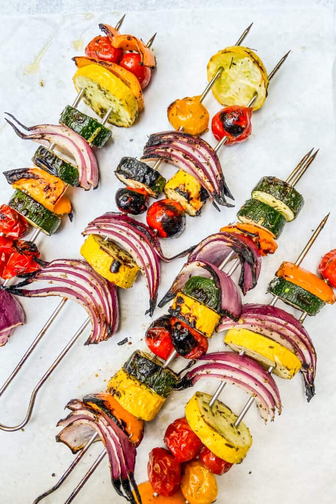 Grilled vegetables on metal skewers after coming off the grill.