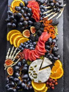 An overhead shot of a halloween charcuterie board on top of black fabric.