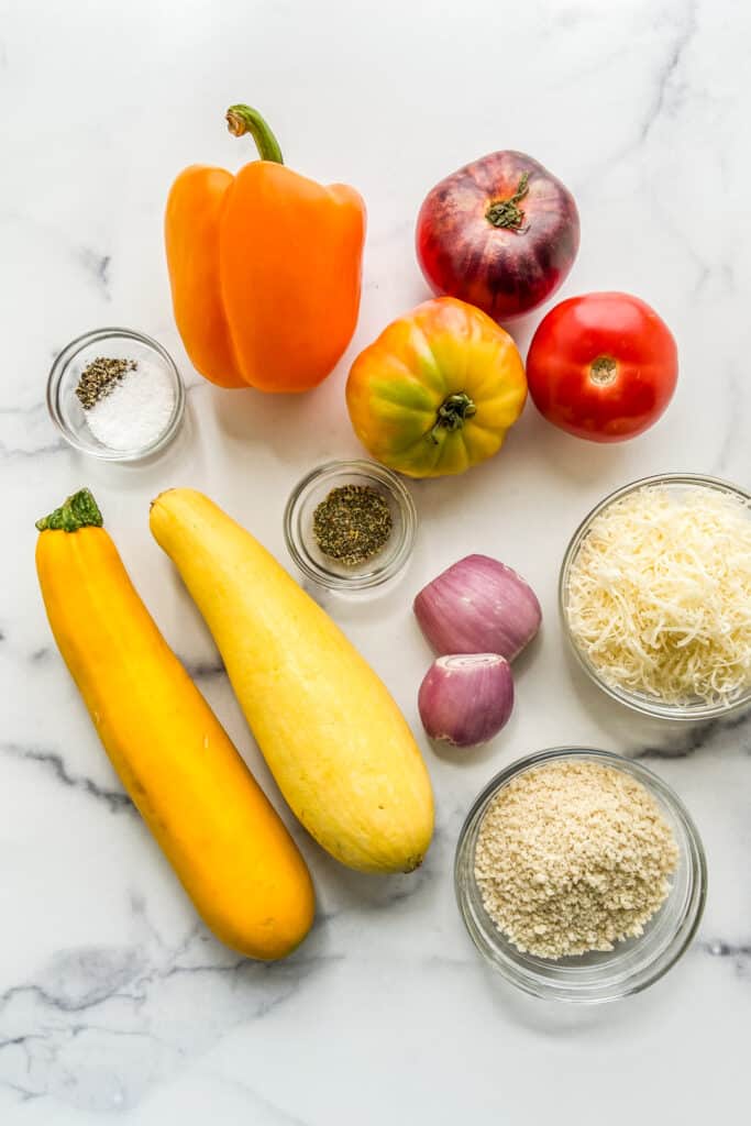 Ingredients for a summer squash, tomato, and bell pepper gratin.