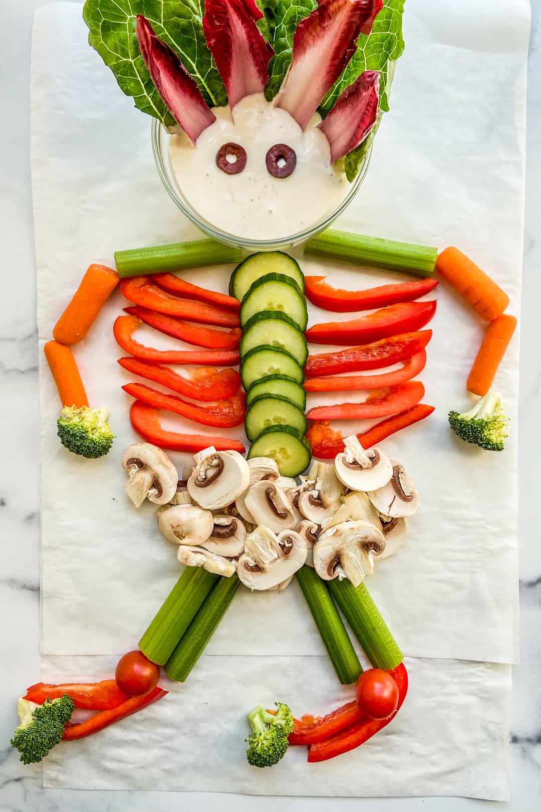 An overhead shot of a skeleton made out of cut vegetables.