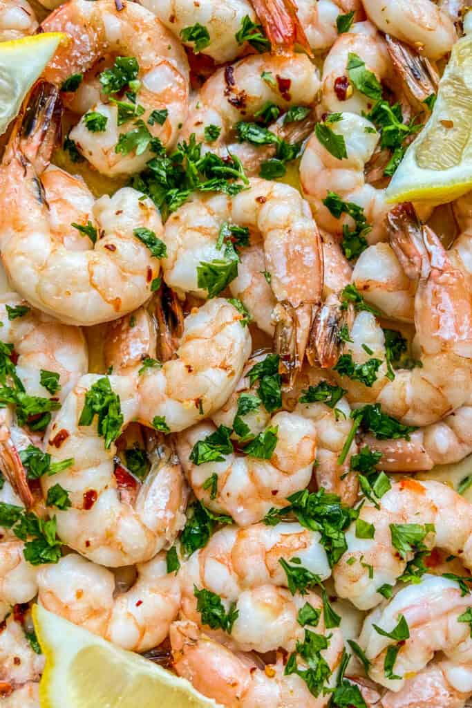 A closeup shot of baked shrimp topped with parsley.