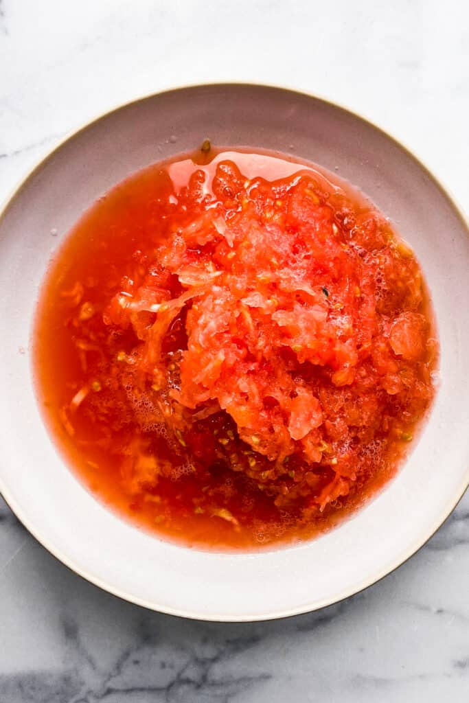 Shredded tomatoes in a white bowl.