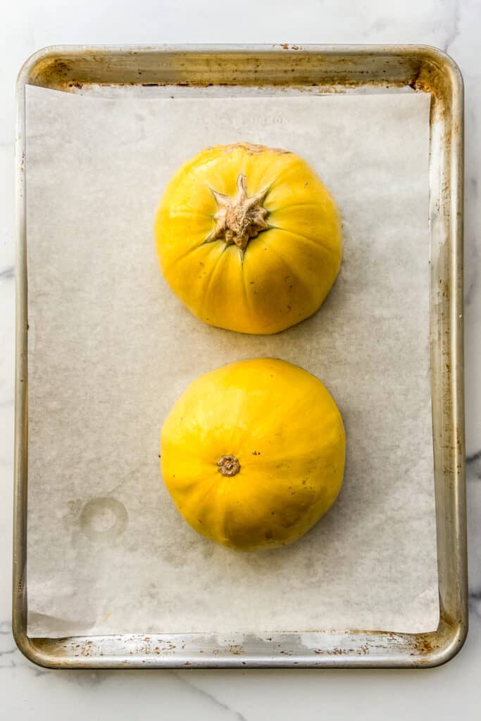 Spaghetti squash on a parchment lined baking tray.