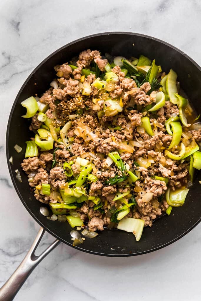 Ground pork stir fry in a black skillet.