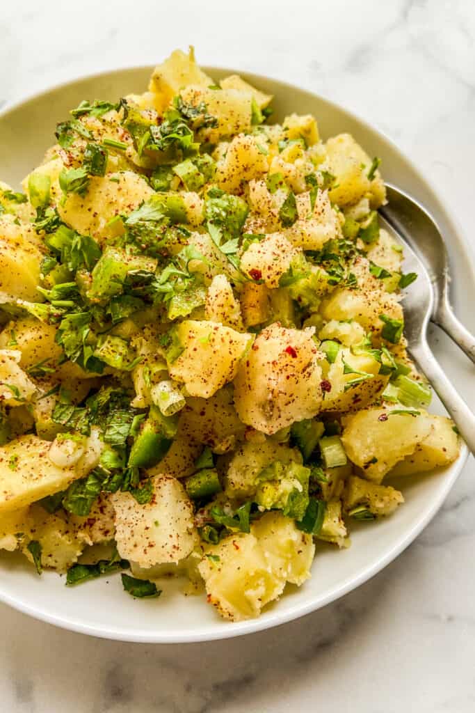 A closeup shot of a bowl of Turkish potato salad. 