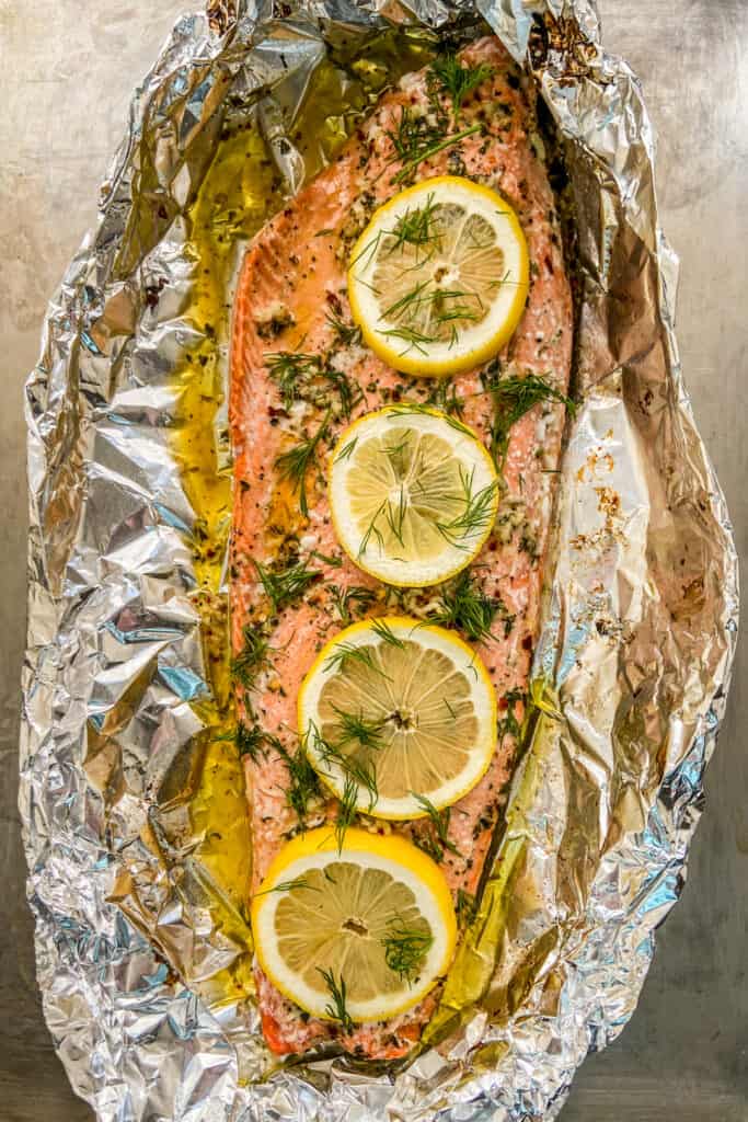 Baked sockeye salmon in foil on a baking sheet.