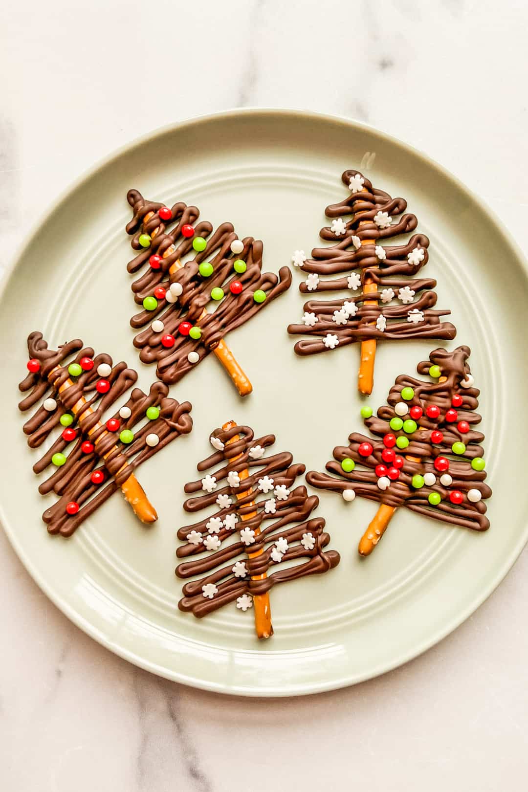 A small green plate with dark chocolate Christmas trees.