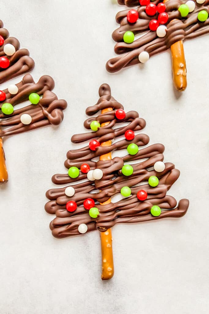 A closeup shot of a dark chocolate Christmas tree with white, green, and red sprinkles.