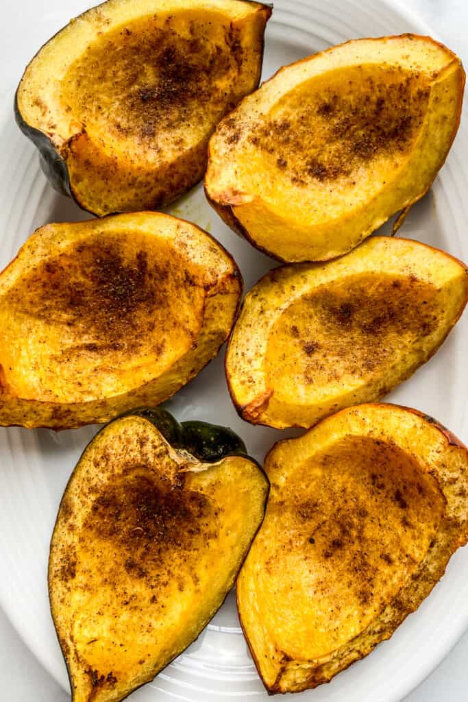 Roasted acorn squash on a white serving dish.