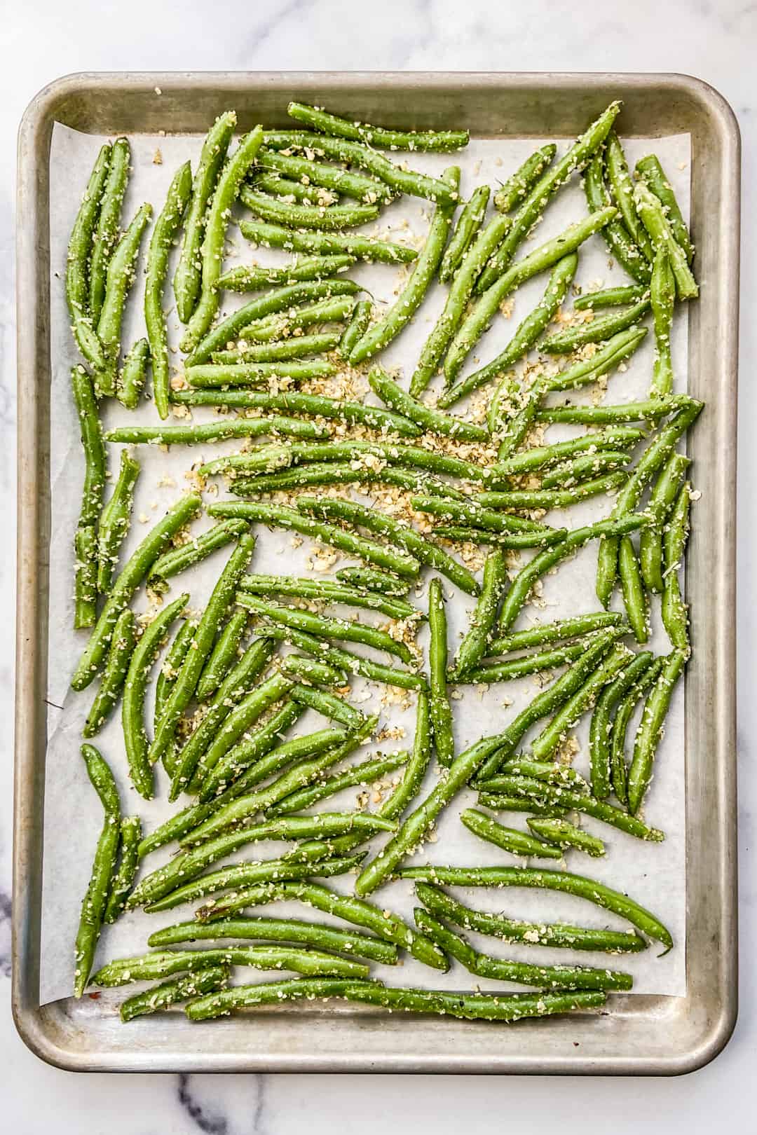 Parmesan green beans on a baking sheet before going in the oven.