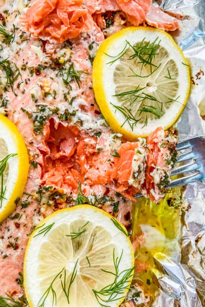 A fork flaking a piece of roasted sockeye salmon.