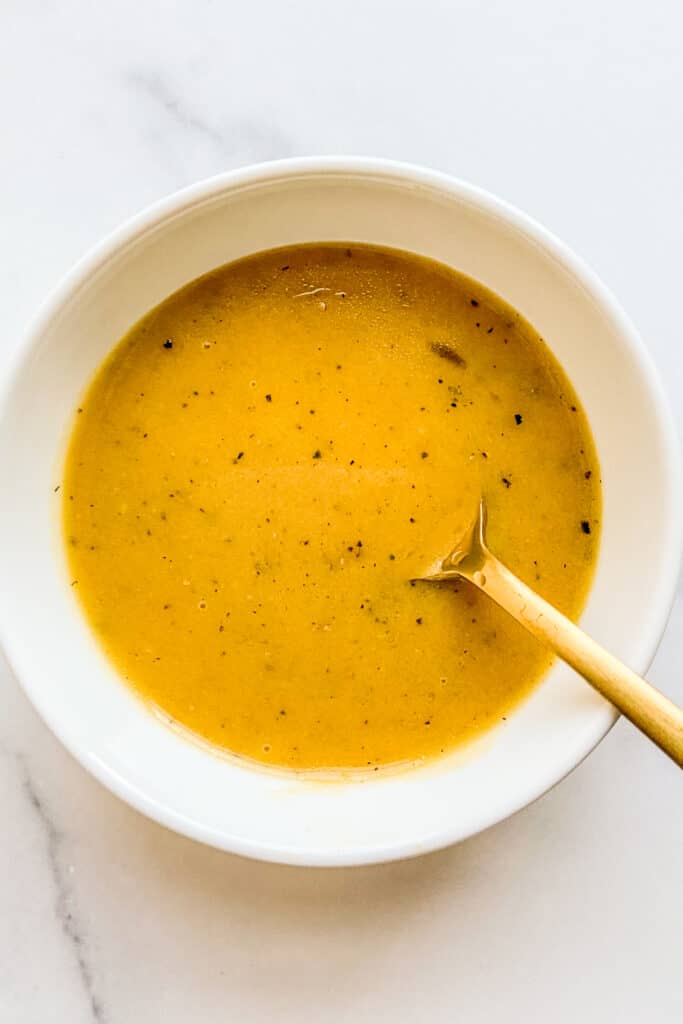 Dijon mustard and honey dressing in a white bowl.