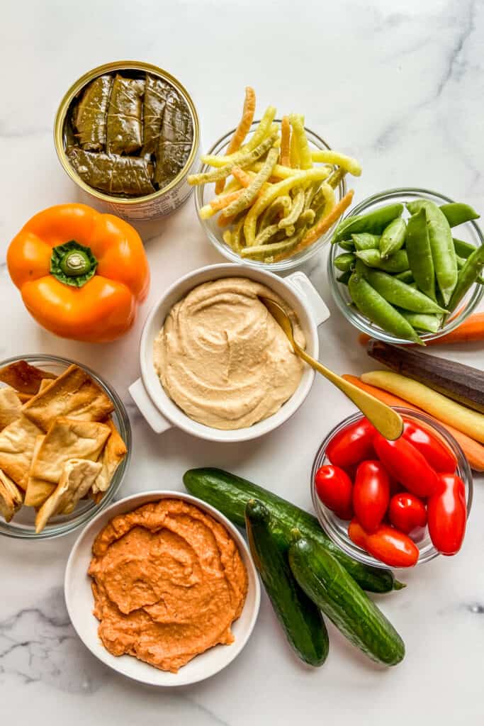 Hummus dip ideas with two bowls of hummus on a marble background.