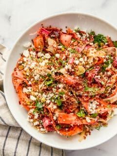 Rainbow carrot quinoa salad in a white serving bowl.