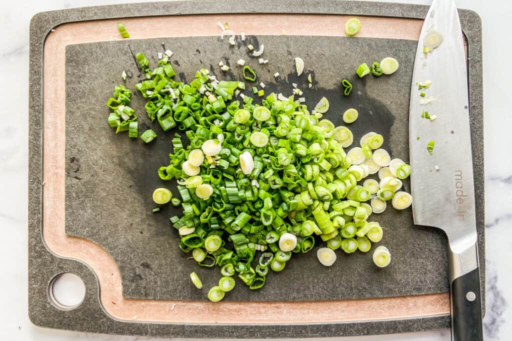 Chopped green onions on a cutting board.