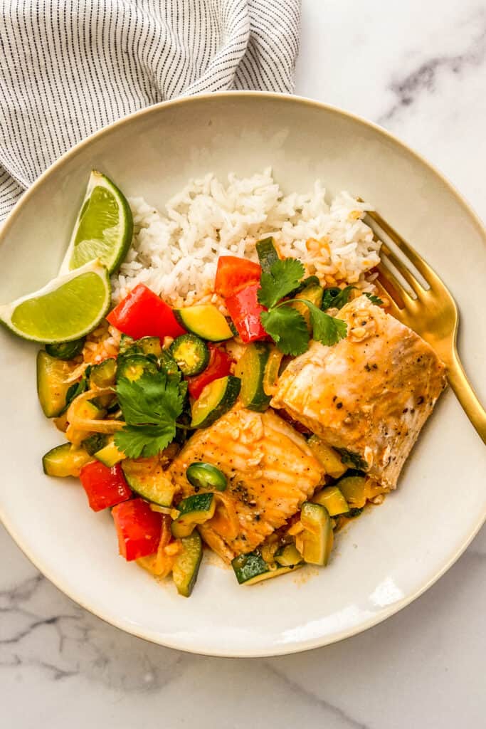 Fish curry with coconut milk served with rice and limes.