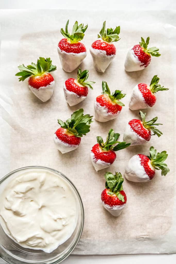 Dipping strawberries in vanilla yogurt.