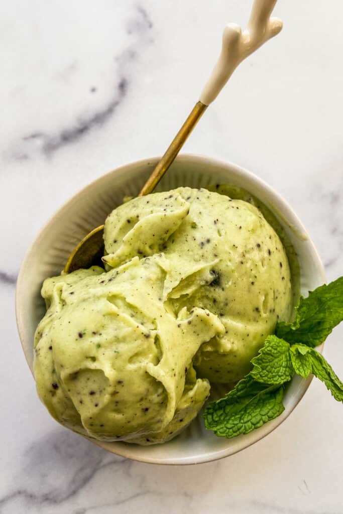 Two scoops of kiwi sorbet in a bowl.