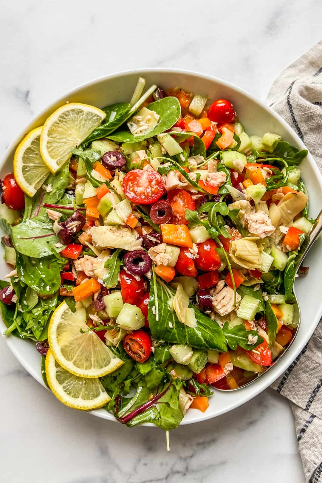 A Mediterranean tuna salad in a large white serving bowl.