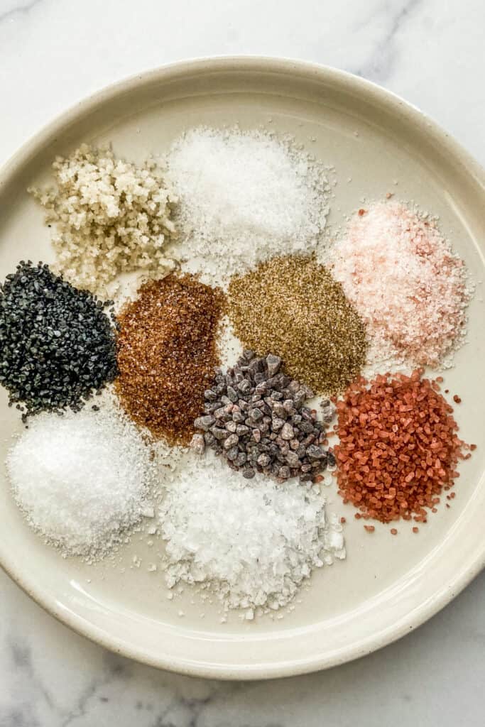 Ten types of salt on a white plate.