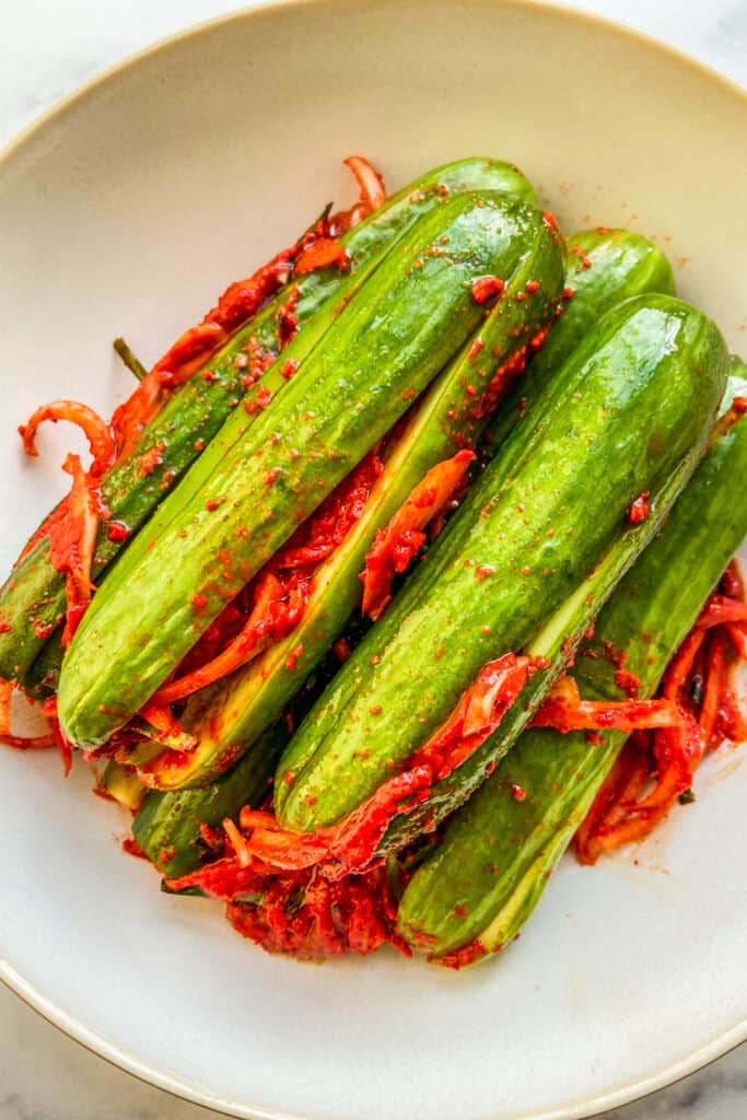 Cucumber kimchi in a white bowl.