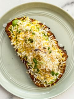 Grated egg avocado toast on a small green plate.