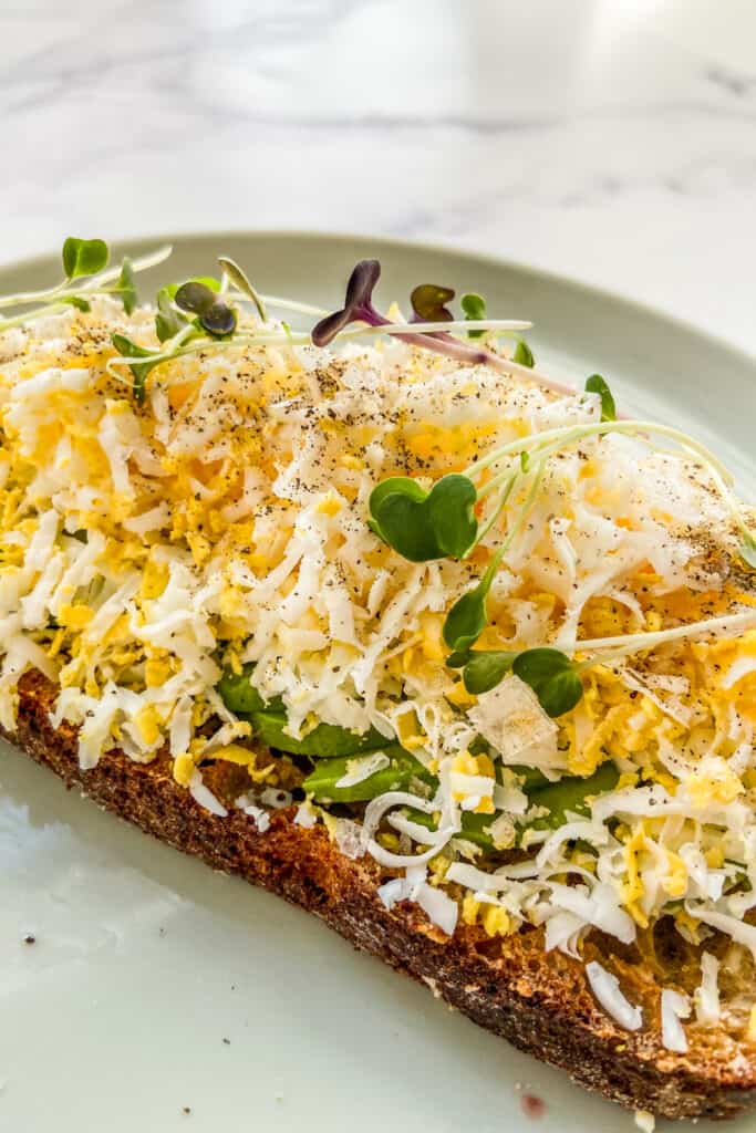 Grated egg on avocado toast from the side.