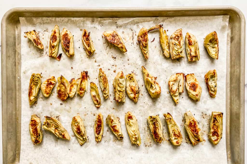 Roasted artichokes on a baking sheet.