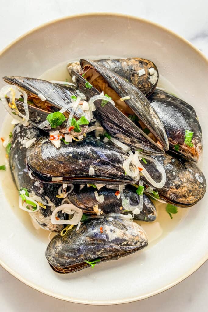 White wine mussels with garlic and shallots in a bowl.