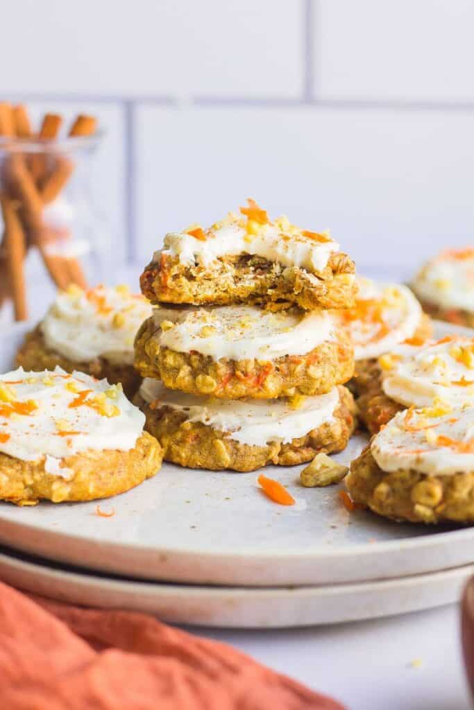 Carrot cake cookies in a stack on a white plate.