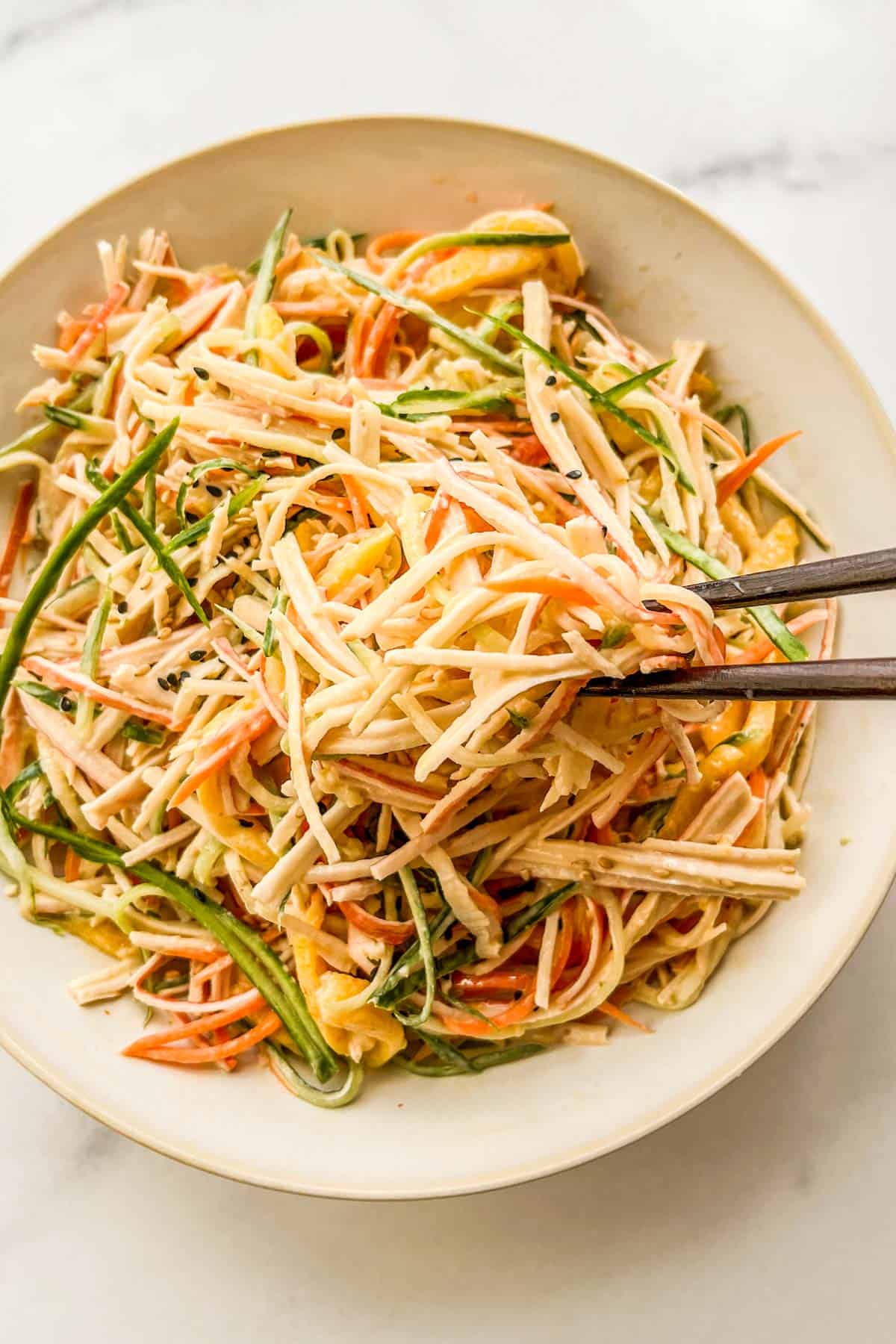 Spicy kani salad in a bowl with chopsticks.