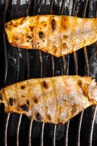 Snapper, skin side up, on a grill.
