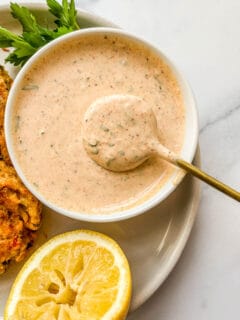 Remoulade for crab cakes in a small bowl with a spoon.