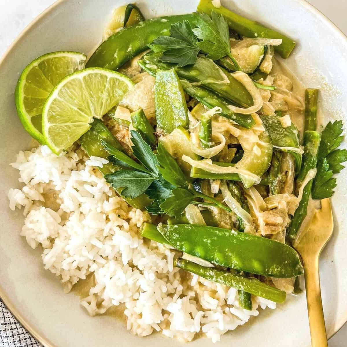 Vegetarian Thai green curry in a bowl with a gold fork.